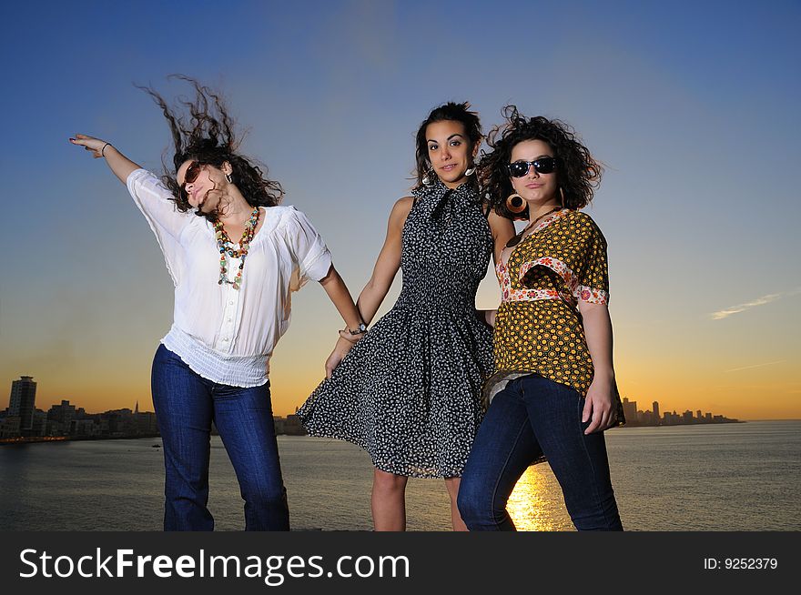 Portrait of three trendy girls posing at sunset. Portrait of three trendy girls posing at sunset