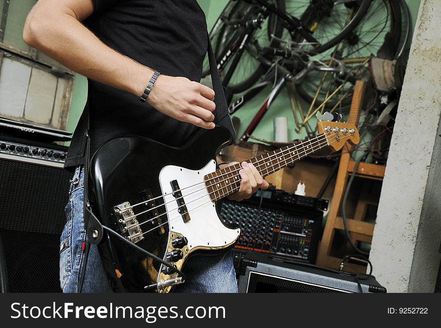 Portrait of man playing electric bass guitar on grunge garage. Portrait of man playing electric bass guitar on grunge garage