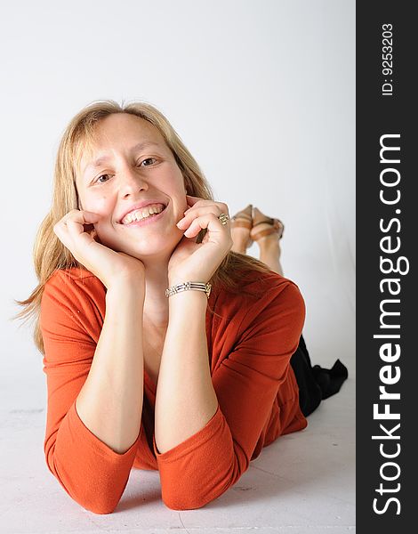 A colorful women laying down with hands under her chin. A colorful women laying down with hands under her chin