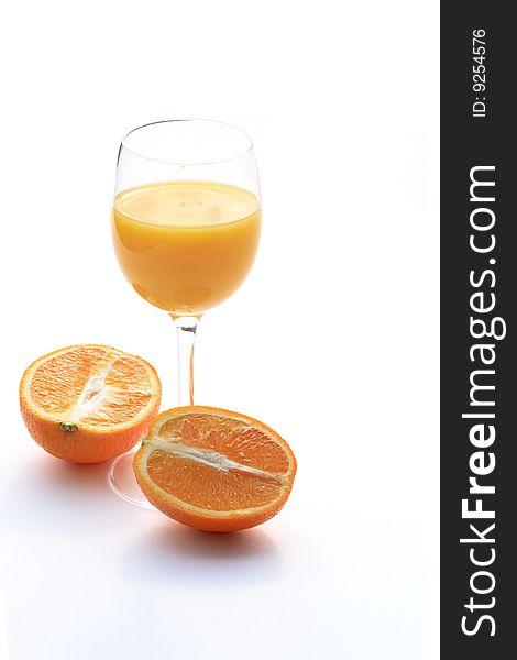 Orange lying near goblet of orange juice isolated on white background