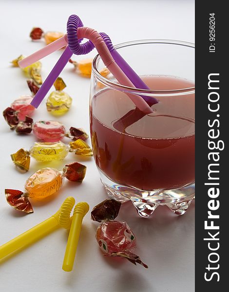 Fruit sugar candy and glass of juice. Fruit sugar candy and glass of juice