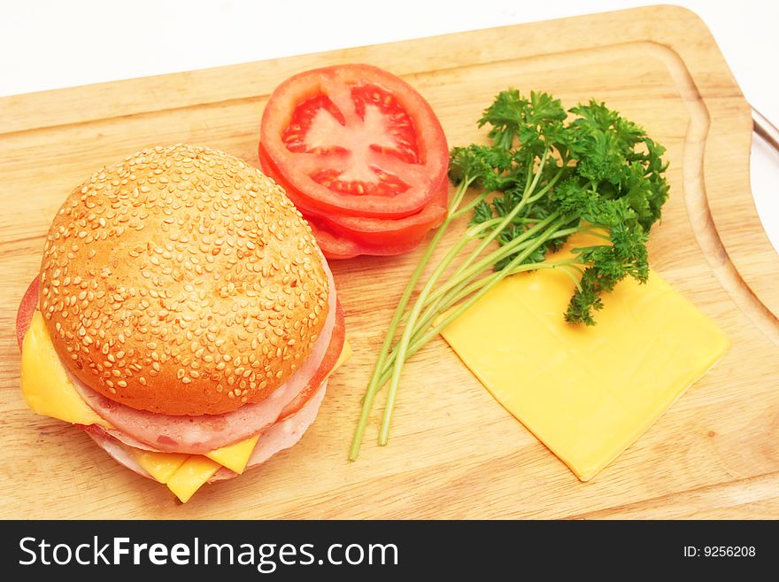 Sandwich and ingredients on wooden plate. Sandwich and ingredients on wooden plate.