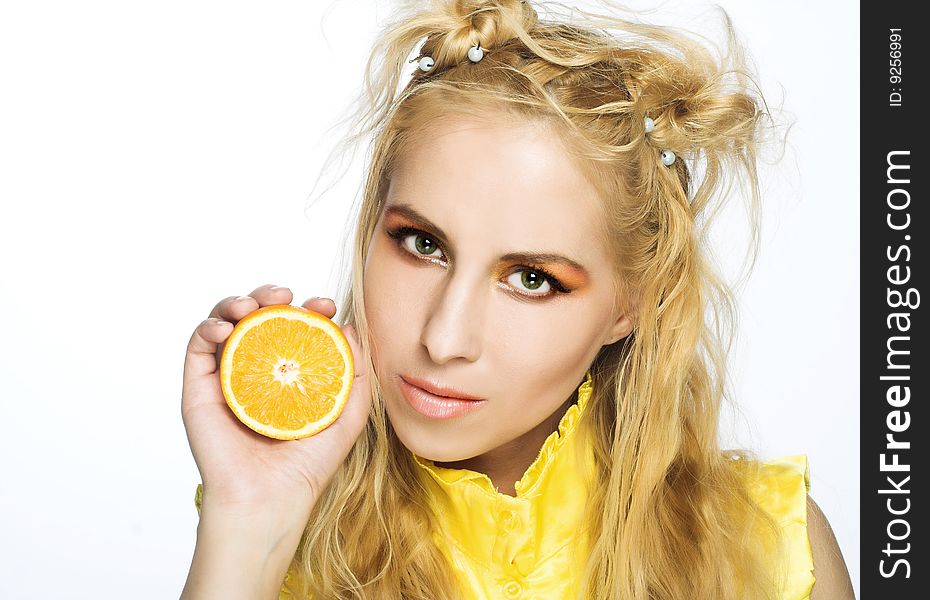 Young girl in yellow dress with piece of orange. Young girl in yellow dress with piece of orange