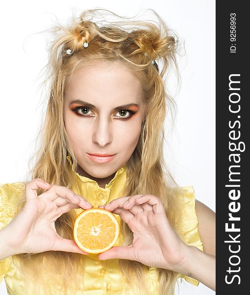 Young girl in yellow dress with piece of orange. Young girl in yellow dress with piece of orange