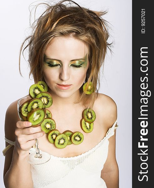 Portrait of young attractive woman with pieces of kiwi. Portrait of young attractive woman with pieces of kiwi