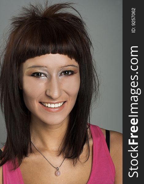 Portrait of young smiling woman in pink shirt