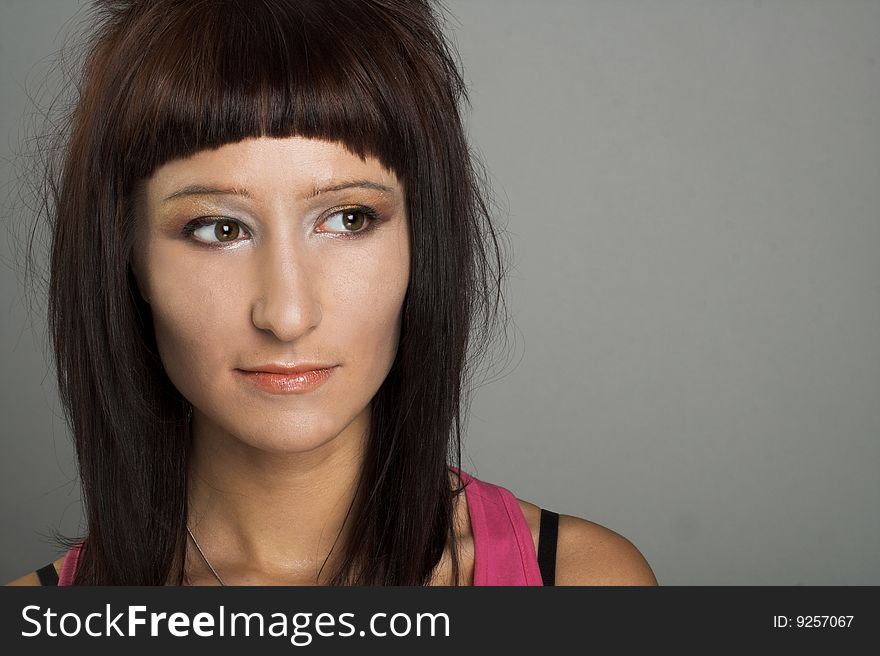 Portrait of young  woman witn dark hair in pink shirt. Portrait of young  woman witn dark hair in pink shirt