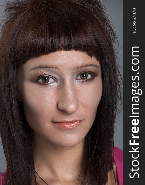 Portrait of young  woman witn dark hair in pink shirt. Portrait of young  woman witn dark hair in pink shirt