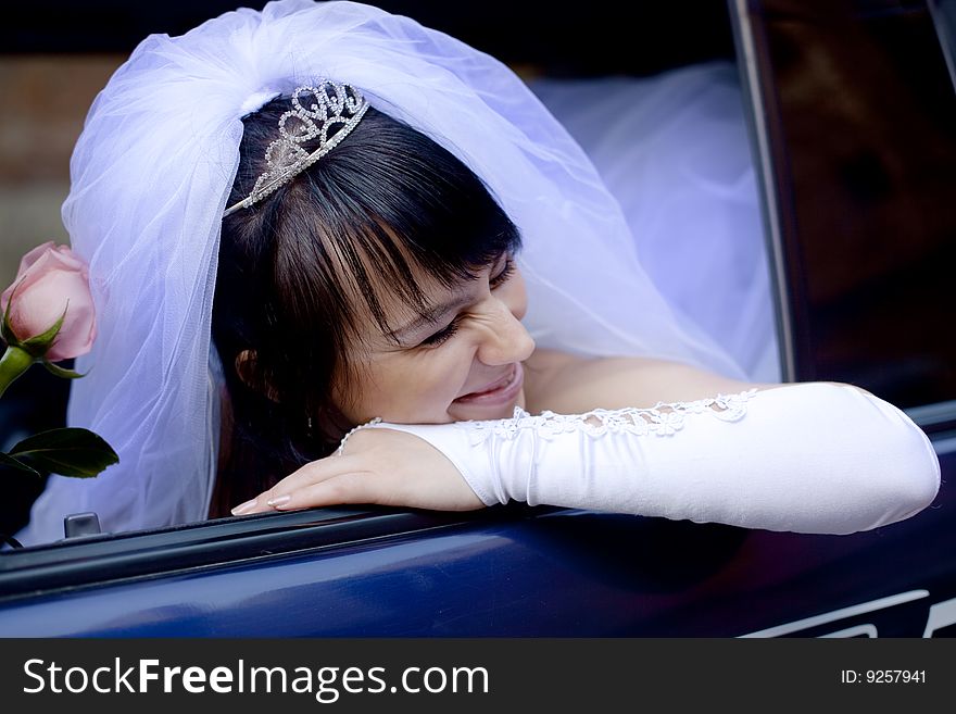 Pretty bride with rose in car