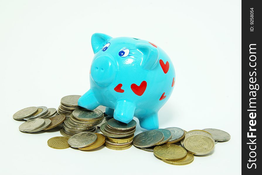 Piggy bank with golden coins, isolated on white.