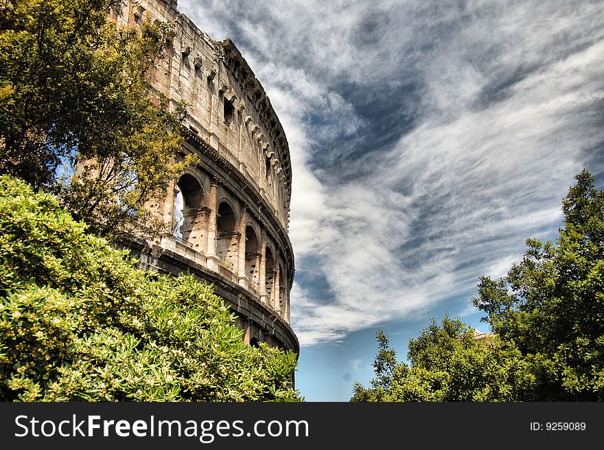 A foreshortening, HDR modified, of the roman colosseum with clouds and trees. A foreshortening, HDR modified, of the roman colosseum with clouds and trees.