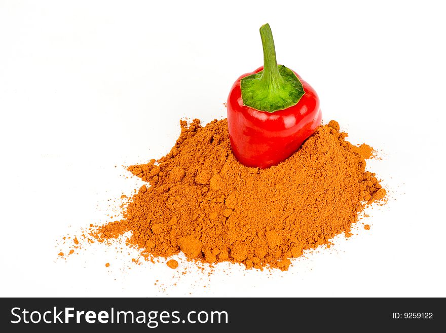 A pod of red hot pepper put  into  ground pepper on a white background. A pod of red hot pepper put  into  ground pepper on a white background