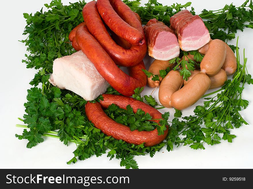 Sausage wares on a background greenery, studio shot