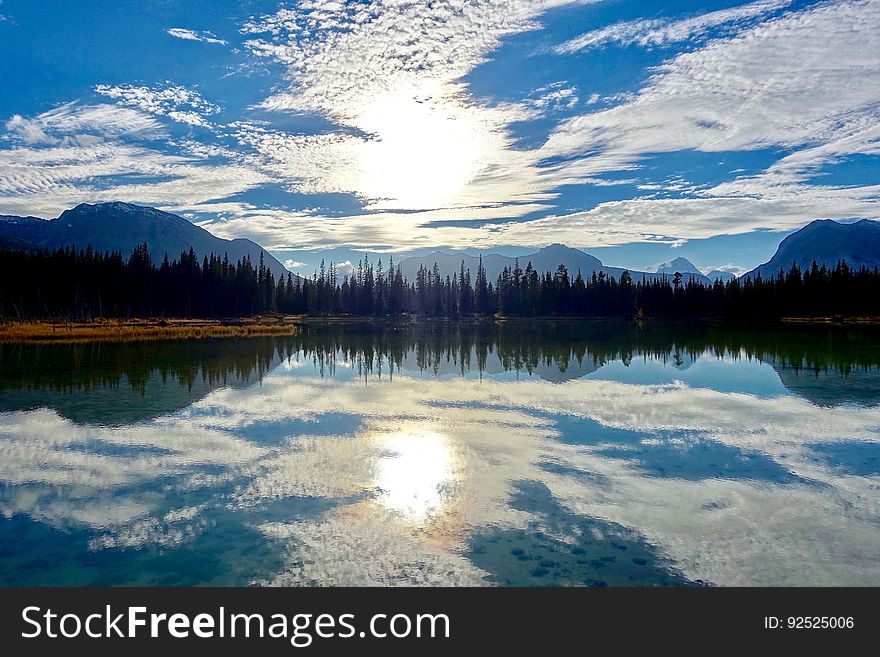 A beautiful lake with a forest and sky reflecting in the water. A beautiful lake with a forest and sky reflecting in the water.