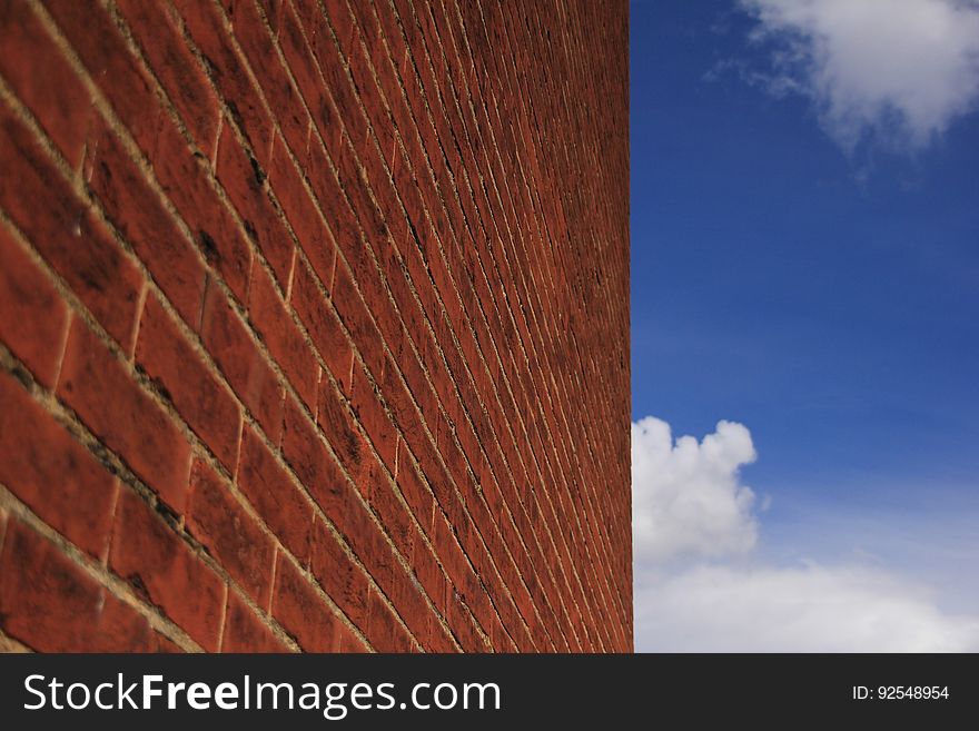 Blue sky with clouds and a wall.