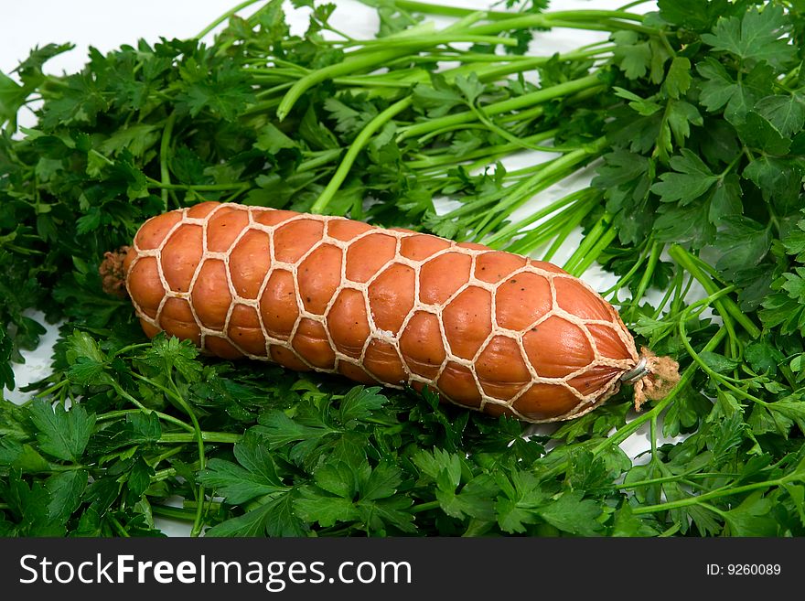 Sausage wares on a background greenery, studio shot