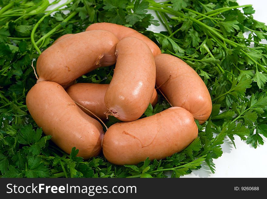 Sausage wares on a background greenery, studio shot