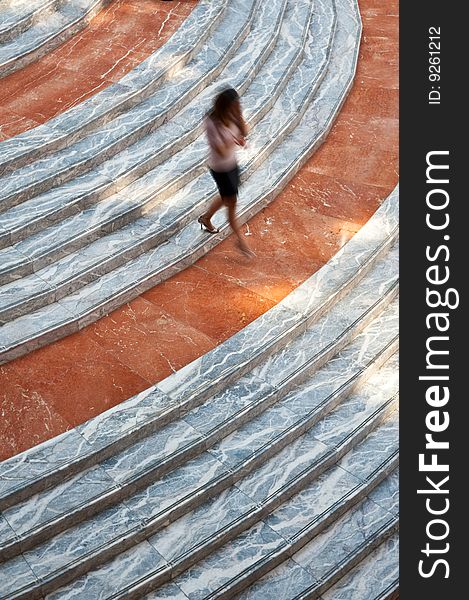 Person walking down orange and white marble stairs. Person walking down orange and white marble stairs.