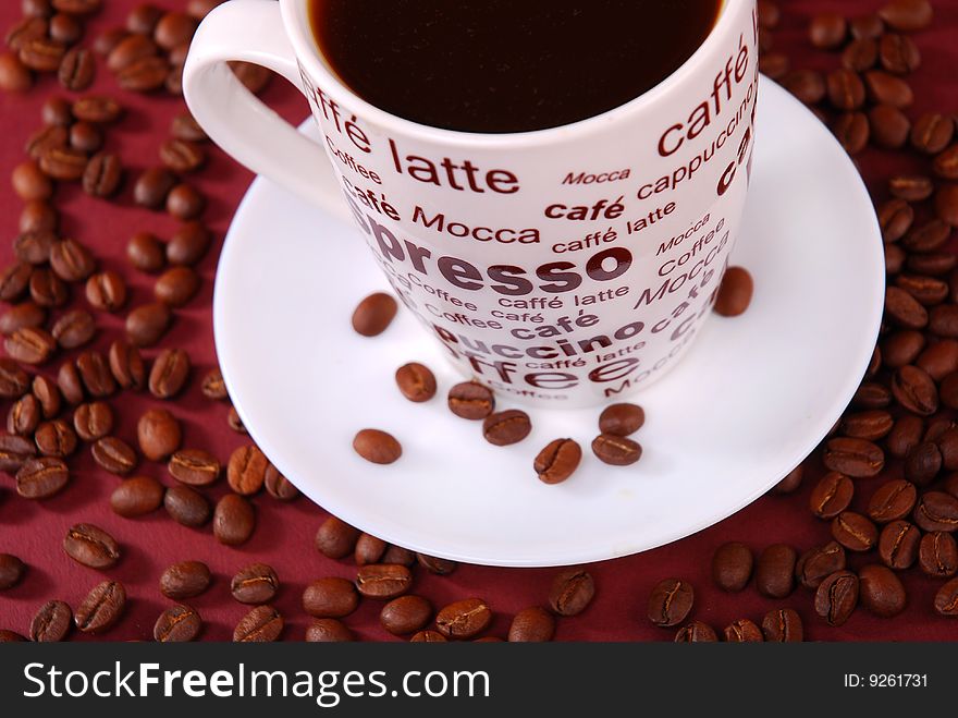 Coffee in white cup with coffee beans around
