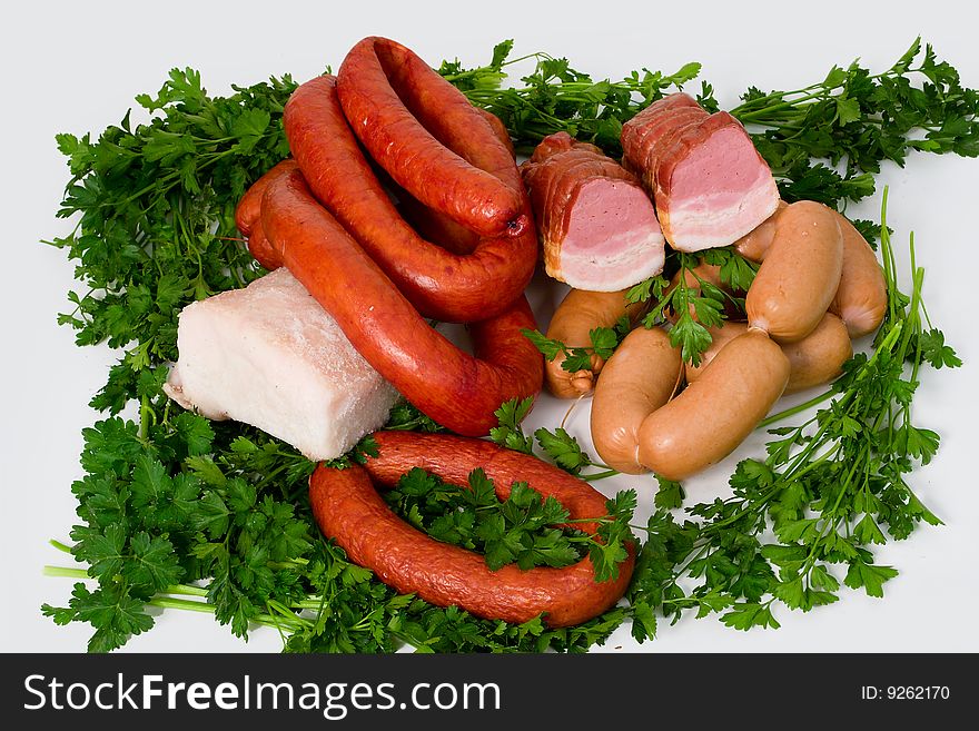 Sausage wares on a background greenery, studio shot