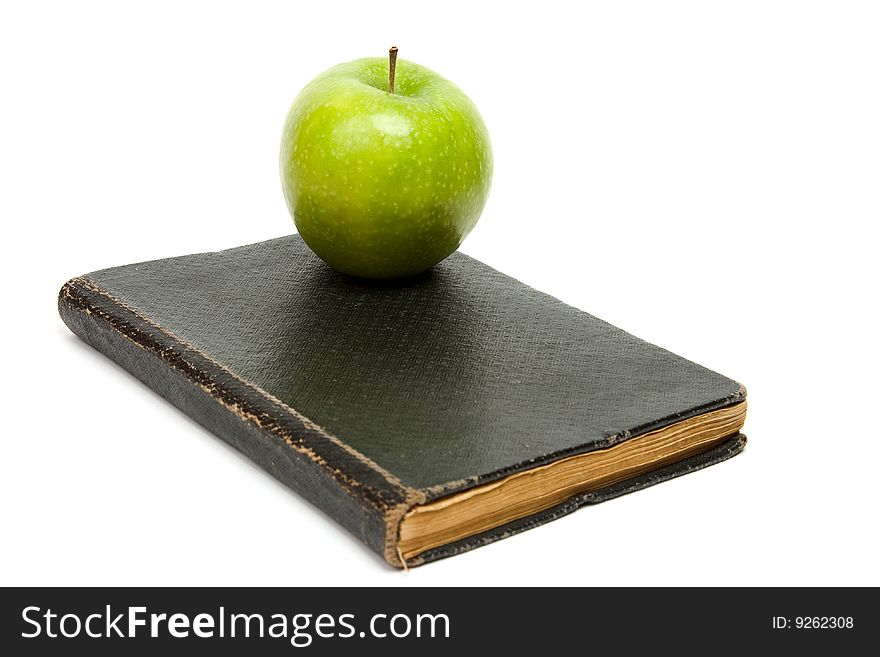 Book and green apple. White background