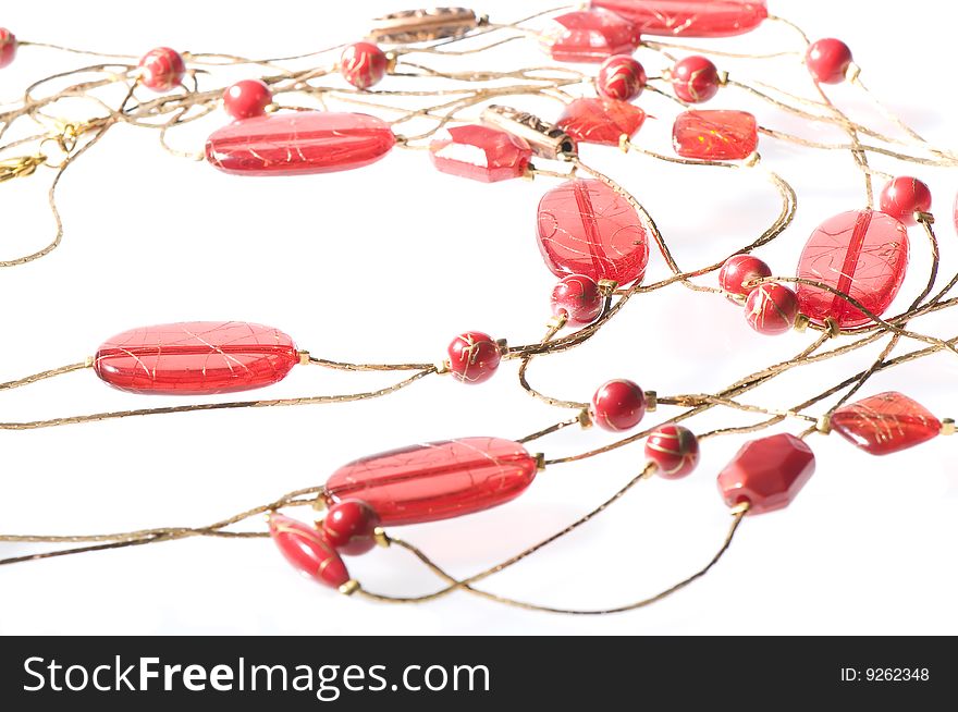 Red colored necklace on white surface