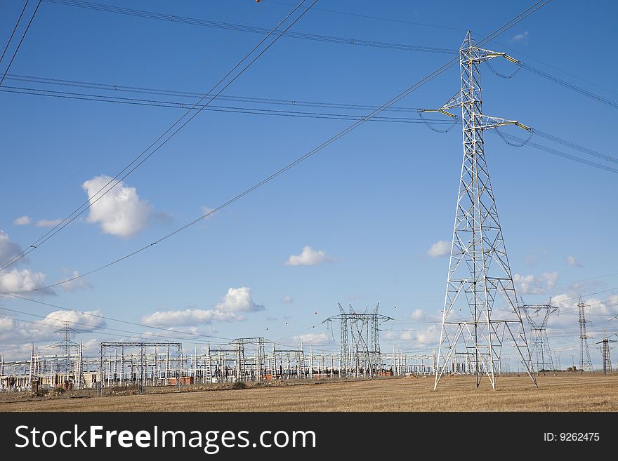 Lots of electricity pylons against blue sky