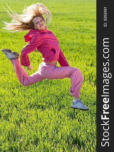 Beautiful young woman jumps above green meadow. Beautiful young woman jumps above green meadow