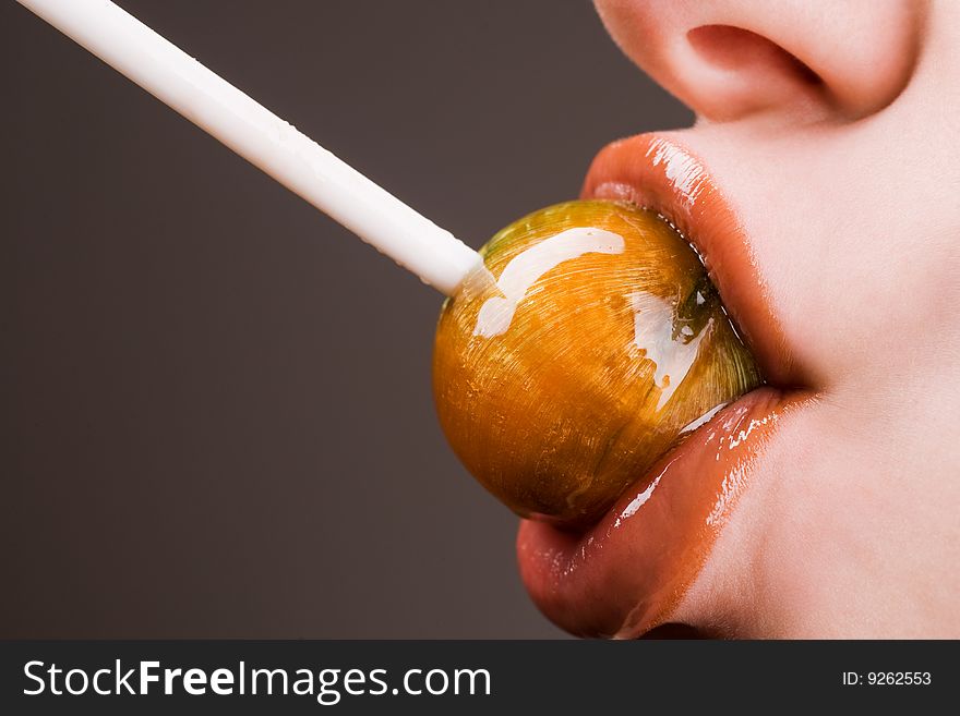 Pretty girl lips sucking lollipop closeup