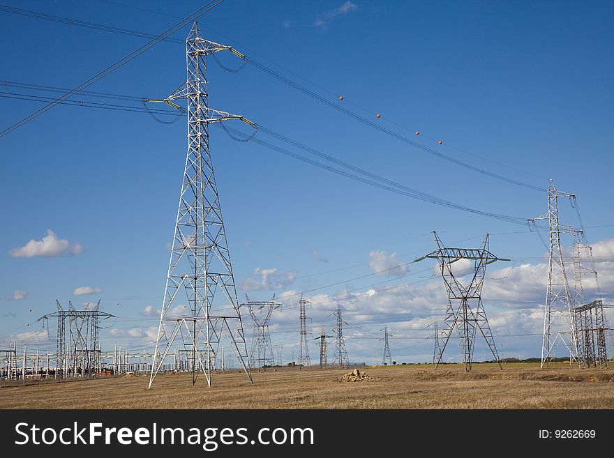 Lots of electricity pylons against blue sky