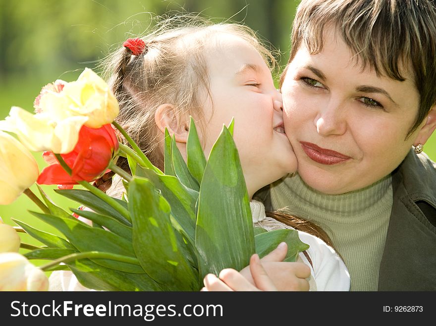 Little girl kissing her mom. Little girl kissing her mom