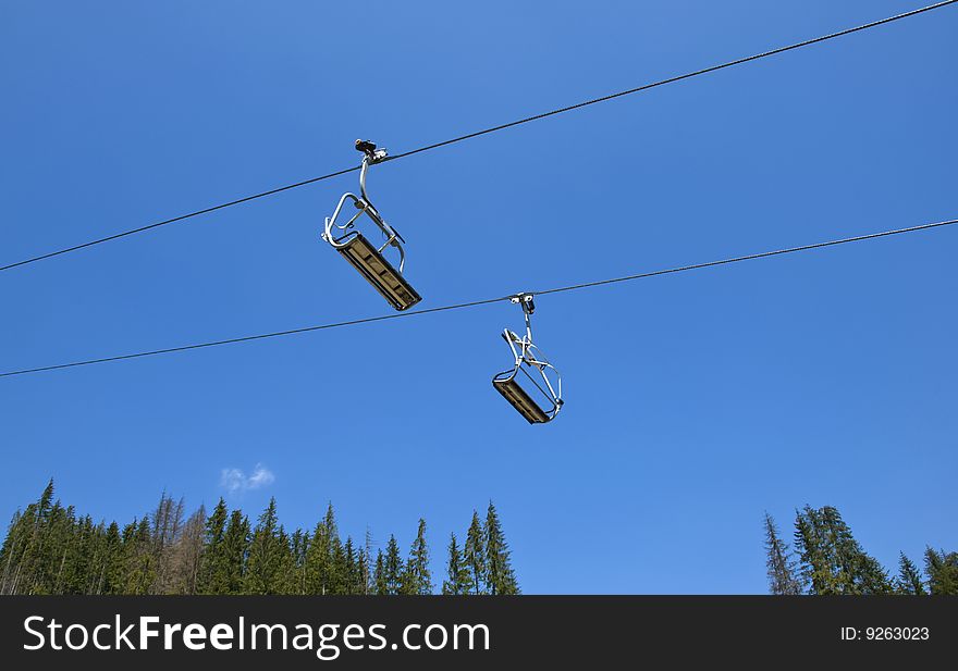 Two chair lifts on blue sky background. Two chair lifts on blue sky background