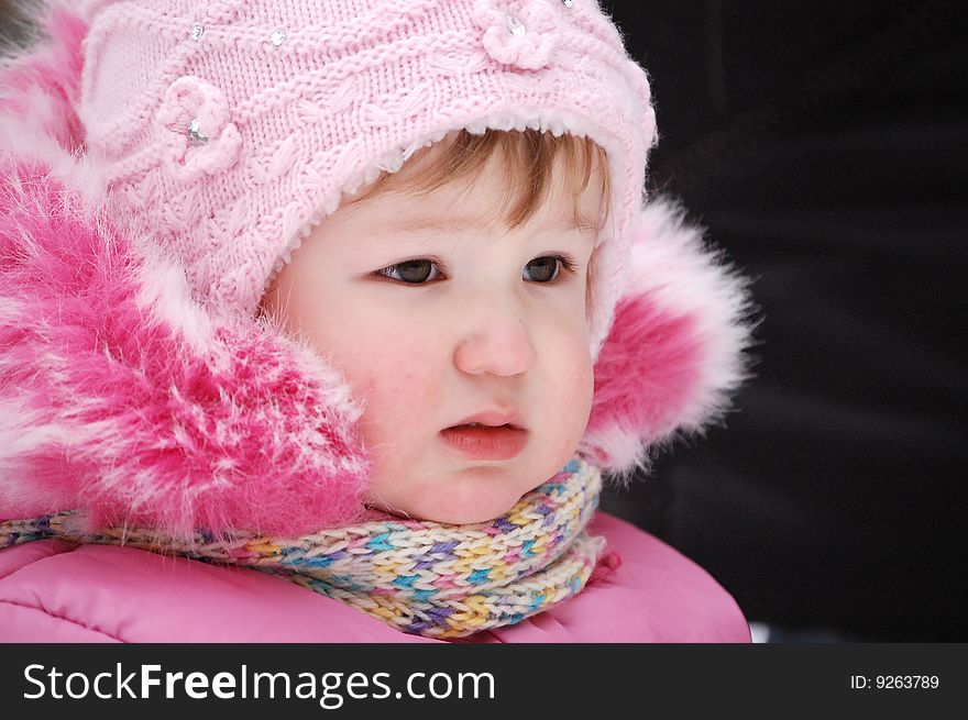 Winter portrait of the little girl in the pink