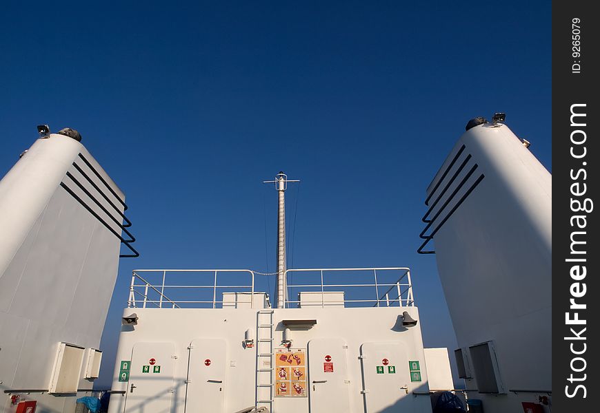 White smokestacks on a ferry with blue sky and sundeck. White smokestacks on a ferry with blue sky and sundeck.