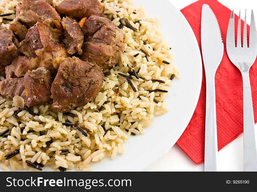 Fried beef with rice and tablewares on a red napkin. Fried beef with rice and tablewares on a red napkin