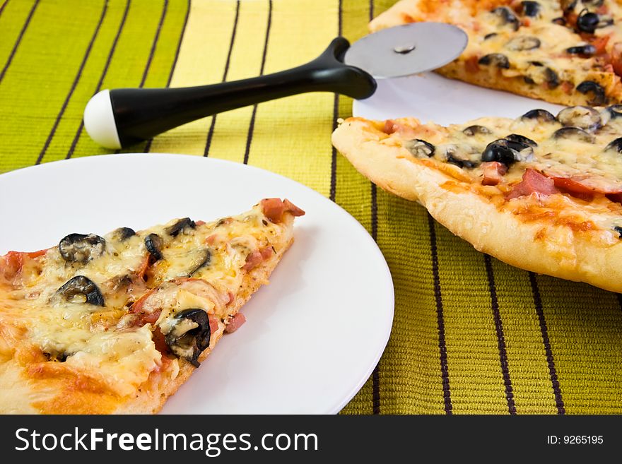 Portion of a fresh pizza on a striped cloth