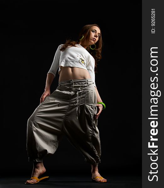 Dancing young girl from low point against a black background