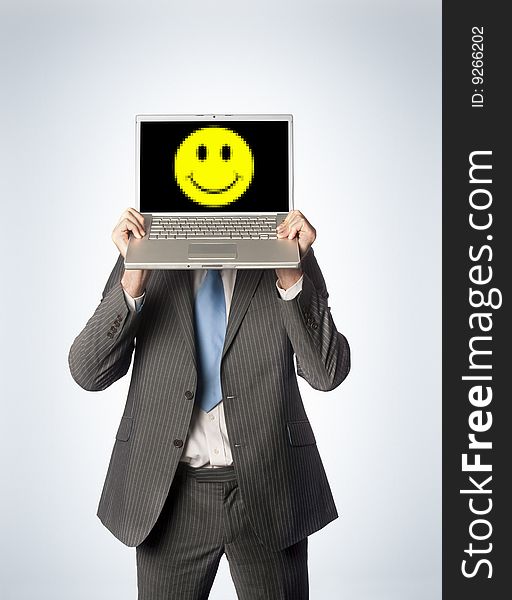 A businessman holding up a smiling laptop. A businessman holding up a smiling laptop