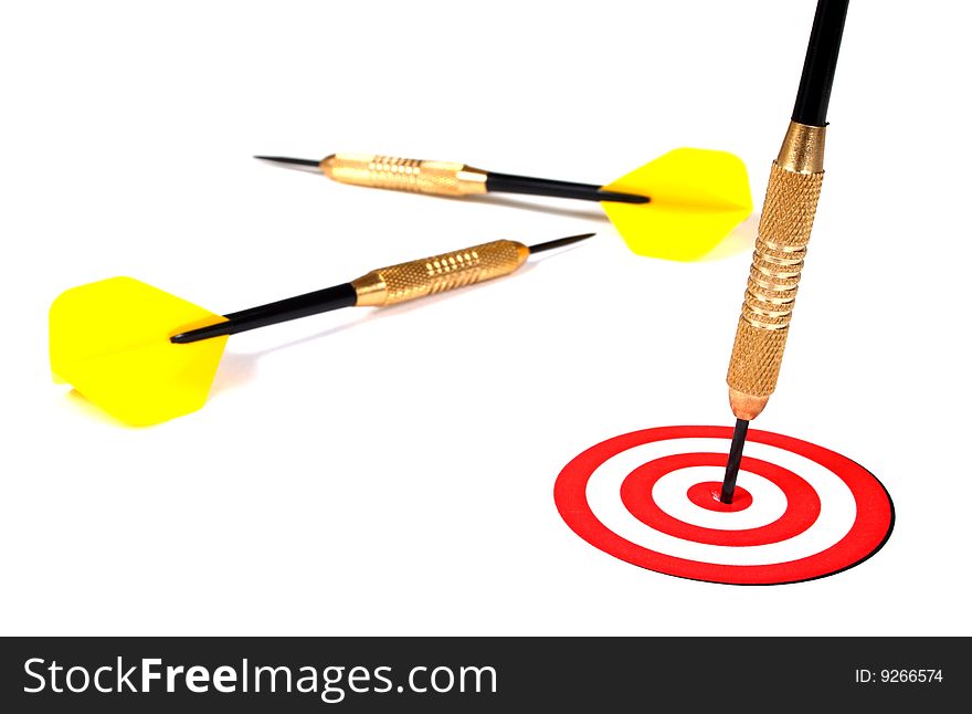 Yellow dart pinned to the center of a red target on a white background. Yellow dart pinned to the center of a red target on a white background