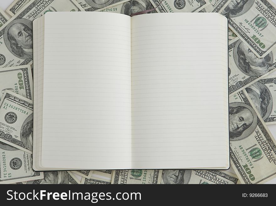 Blank Notebook with one hundred dollar bills in background. Blank Notebook with one hundred dollar bills in background