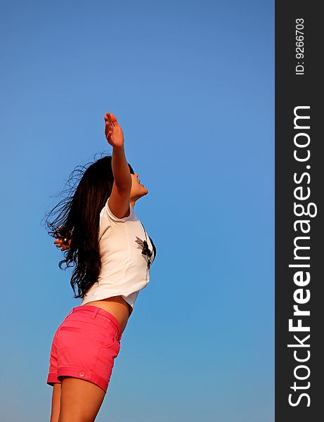 Young Woman opening her arms to blue Sky. Young Woman opening her arms to blue Sky
