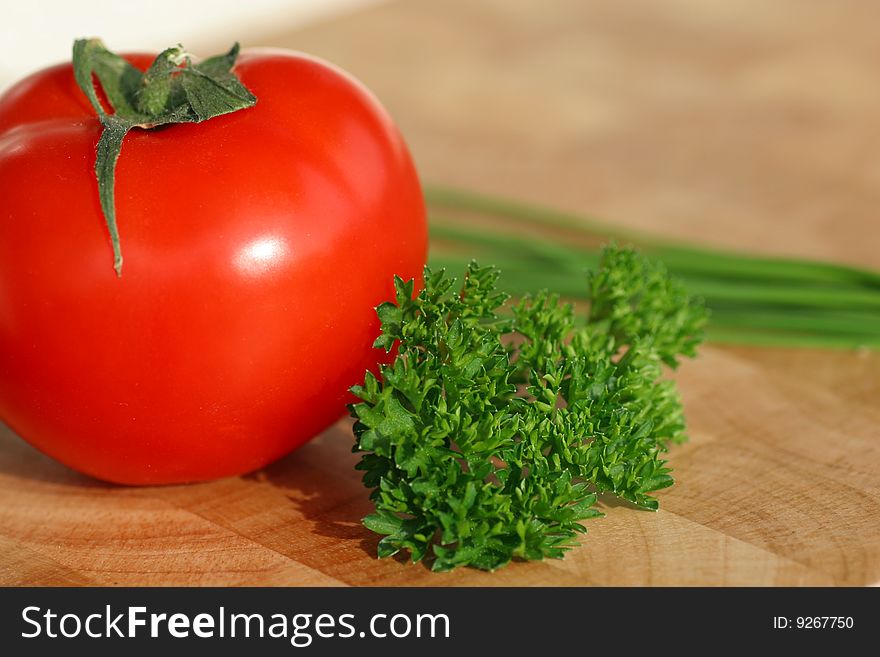 Red Tomato with green parsley, brown background. Red Tomato with green parsley, brown background