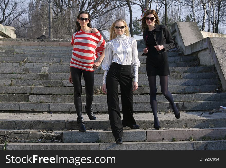 Three fashion women posing on the steps. Three fashion women posing on the steps