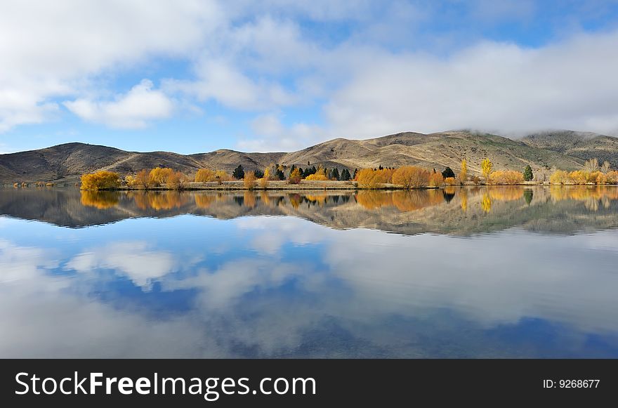 Wide angle landscape, yellow trees beside the lake, perfect reflection. Wide angle landscape, yellow trees beside the lake, perfect reflection