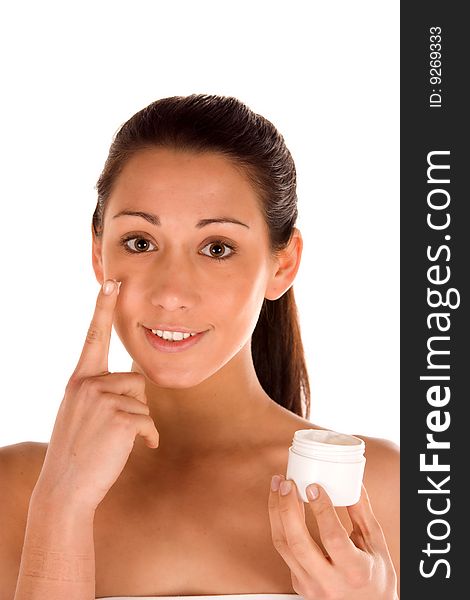 Nice attractiveyoung caucasian brunette applying cream on the face isolated on white.Concept of skincare. Nice attractiveyoung caucasian brunette applying cream on the face isolated on white.Concept of skincare