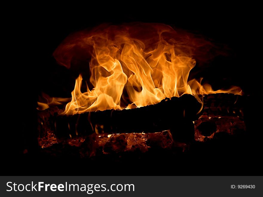 Burning wooden fire wood in the furnace on a black background. Burning wooden fire wood in the furnace on a black background
