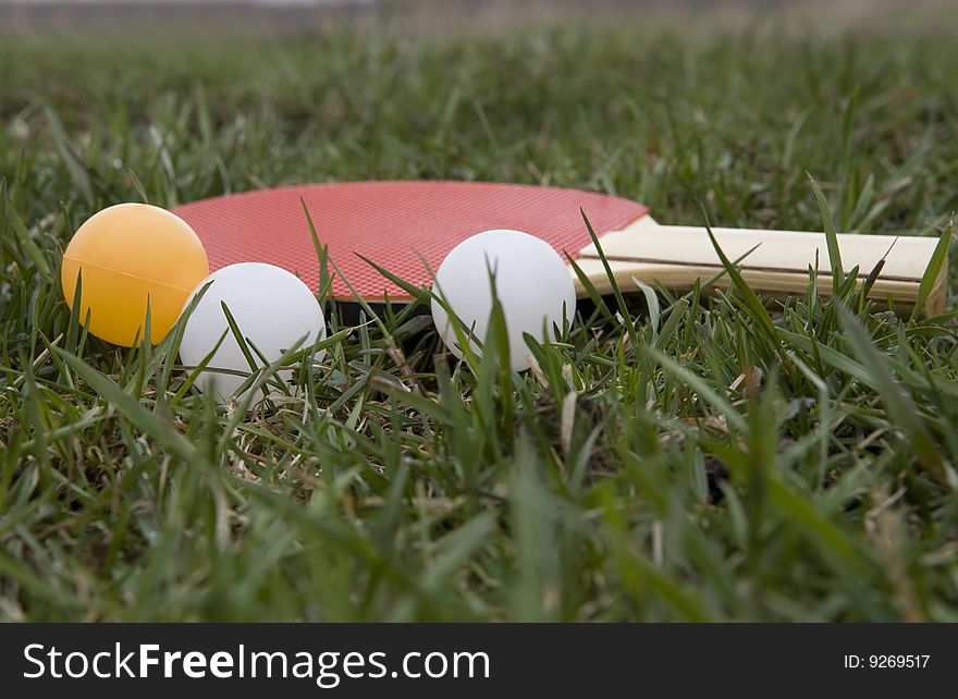 Tennis balls and racket on a green grass