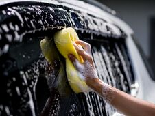 Woman Hand With Yellow Sponge Washing Car Royalty Free Stock Image