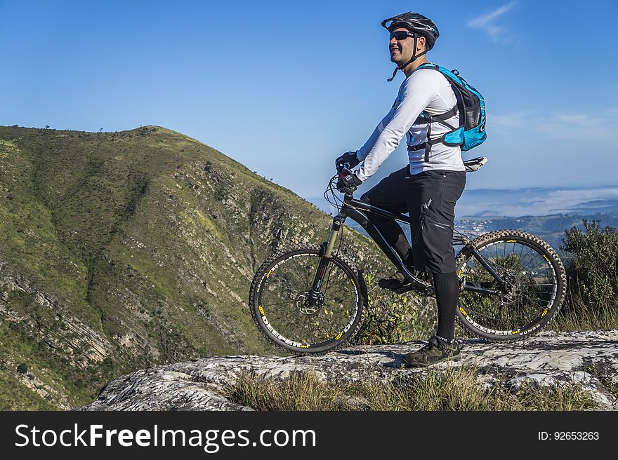 Man With White Shirt Riding Abicycle on a Mountain