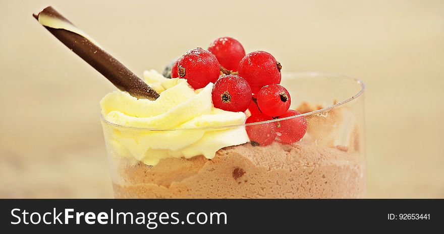 A cup of chocolate mousse with cream and red currants. A cup of chocolate mousse with cream and red currants.